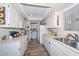 Well-lit kitchen featuring white cabinets, modern appliances, and lots of counter space at 13423 W Countryside Dr, Sun City West, AZ 85375