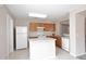 Well-lit kitchen featuring white appliances, a white island, and wooden cabinets for ample storage space at 13646 W Fargo Dr, Surprise, AZ 85374