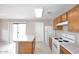 Bright kitchen with white appliances, wooden cabinets, and a center island with a white countertop at 13646 W Fargo Dr, Surprise, AZ 85374