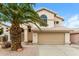 Beige two story home featuring a tile roof, arched window, two car garage and a palm tree in the front yard at 1406 W Charleston Ave, Phoenix, AZ 85023