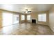 Open-concept living room featuring tile flooring, a fireplace, and a sliding glass door leading to the backyard at 1406 W Charleston Ave, Phoenix, AZ 85023