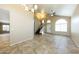 Open living room with tile flooring, staircase, and view of the entrance and dining area through arched windows at 1406 W Charleston Ave, Phoenix, AZ 85023