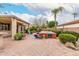 Paver patio with a built-in spa, lush plants and trees in a well-maintained backyard at 14686 W Clarendon Ave, Goodyear, AZ 85395