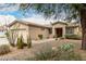 Single-story home featuring desert landscaping, flower pots, and walkway to front door at 14686 W Clarendon Ave, Goodyear, AZ 85395