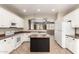 Bright kitchen with white cabinets, a black island, and an open view to the living area at 14686 W Clarendon Ave, Goodyear, AZ 85395