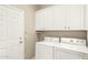 Bright laundry room featuring a side-by-side washer and dryer and lots of storage at 14686 W Clarendon Ave, Goodyear, AZ 85395