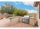 Outdoor kitchen with stainless steel gas grill and counter, set in a brick paved patio area at 14686 W Clarendon Ave, Goodyear, AZ 85395