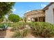 Lush backyard featuring beautiful plants, a pergola, and a covered patio at 15750 W Linksview Dr, Surprise, AZ 85374