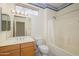 Well-lit bathroom with a single vanity, decorative wallpaper, and a shower-tub combo at 15750 W Linksview Dr, Surprise, AZ 85374