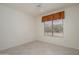 Bright, airy bedroom featuring neutral decor, tile flooring, and a large window at 15750 W Linksview Dr, Surprise, AZ 85374