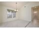 Bright dining area featuring neutral carpeting, tile accents, a chandelier, and a window with sunny views at 15750 W Linksview Dr, Surprise, AZ 85374