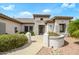 Close-up of a charming home entrance featuring desert landscaping, mature plants and a secure front door at 15750 W Linksview Dr, Surprise, AZ 85374