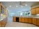 Bright kitchen with light wood cabinets and counter seating that opens to a dining area at 15750 W Linksview Dr, Surprise, AZ 85374