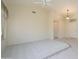 Bright living room featuring vaulted ceiling, neutral carpeting, tile accents, and a sun-filled window at 15750 W Linksview Dr, Surprise, AZ 85374