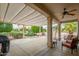 Large covered patio featuring comfortable seating, a ceiling fan, and views of lush desert landscaping at 15750 W Linksview Dr, Surprise, AZ 85374