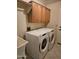 Bright laundry room with modern washer and dryer, cabinet storage, and functional sink at 1635 W Wisteria Dr, Chandler, AZ 85248