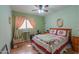 Well-lit bedroom featuring a window, ceiling fan, hardwood floors, and comfortable furnishings at 1814 N Parkside Ln, Casa Grande, AZ 85122