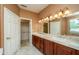 Bathroom with double vanity, granite countertops, wood cabinets and large mirror at 20562 N Bear Canyon Ct, Surprise, AZ 85387