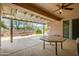 Relaxing covered patio featuring a decorative stone wall and views of the desert landscape at 20562 N Bear Canyon Ct, Surprise, AZ 85387