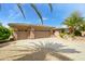 Spacious three-car garage with a long driveway and desert landscaping in the front yard at 20562 N Bear Canyon Ct, Surprise, AZ 85387