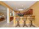 Kitchen bar and dining area, featuring wood cabinets, granite countertops, and overhead lighting at 20562 N Bear Canyon Ct, Surprise, AZ 85387