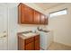 Functional laundry room equipped with overhead cabinets, a utility sink, and modern appliances at 20562 N Bear Canyon Ct, Surprise, AZ 85387