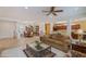 Inviting living room with tile flooring, a ceiling fan, and an open layout to the dining area at 20562 N Bear Canyon Ct, Surprise, AZ 85387