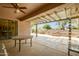 Covered patio featuring a ceiling fan, table, and view of the landscaped backyard at 20562 N Bear Canyon Ct, Surprise, AZ 85387