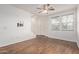 Bright living room features wood flooring, a ceiling fan, and ample natural light, with wall-mounted TV hookups at 2323 E Huntington Dr, Phoenix, AZ 85040