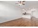 Open floor plan showcases wood flooring, a ceiling fan, and adjacent modern kitchen area for seamless living at 2323 E Huntington Dr, Phoenix, AZ 85040