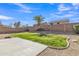 Fenced backyard featuring a concrete patio, green ground cover, palm tree, and easy-to-maintain desert landscaping at 3013 W Pollack St, Phoenix, AZ 85041