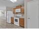 Galley kitchen with white appliances, wood cabinets, and laminate flooring with ample counter space at 3013 W Pollack St, Phoenix, AZ 85041