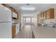 Open kitchen with wood cabinets, white appliances, and laminate flooring overlooking the living room at 3013 W Pollack St, Phoenix, AZ 85041