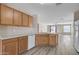 Open kitchen features laminate flooring, wood cabinets, and white appliances with views to the living room at 3013 W Pollack St, Phoenix, AZ 85041