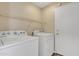 A clean laundry room including a washer, dryer, storage shelving, and access to the outside at 3013 W Pollack St, Phoenix, AZ 85041