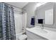 Bright bathroom with a hexagon shower curtain, white vanity, and a large, modern mirror at 30404 N 43Rd St, Cave Creek, AZ 85331