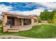 Wide angle view of the brick paver patio area, dining set, putting green, and outdoor kitchen at 3209 W Spur Dr, Phoenix, AZ 85083