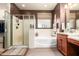 Bright bathroom with a walk-in shower, a soaking tub, and a double sink vanity at 3209 W Spur Dr, Phoenix, AZ 85083