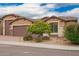 Inviting home exterior with mature desert landscaping, a three-car garage and a brick driveway at 3209 W Spur Dr, Phoenix, AZ 85083