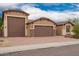 Beautiful home exterior featuring a three car garage and a well-maintained desert landscaped yard at 3209 W Spur Dr, Phoenix, AZ 85083