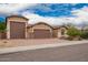 Charming home exterior with a brick driveway, three-car garage and desert landscaping in front at 3209 W Spur Dr, Phoenix, AZ 85083