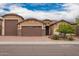 Charming home exterior with three-car garage, desert landscaping, and brick driveway at 3209 W Spur Dr, Phoenix, AZ 85083