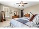 Inviting bedroom featuring soft carpet, a ceiling fan, plantation shutters, and a dresser at 3209 W Spur Dr, Phoenix, AZ 85083