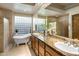 Luxurious bathroom featuring a soaking tub, dual sinks, and a glass block window at 34463 N 99Th Way, Scottsdale, AZ 85262