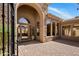 Covered front entrance featuring an arched doorway, stone accents, and a brick walkway at 34463 N 99Th Way, Scottsdale, AZ 85262