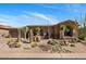 Home's exterior with desert landscaping, barrel cacti, and gravel groundcover at 34463 N 99Th Way, Scottsdale, AZ 85262