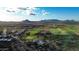 Aerial view of the golf course, desert community and desert mountain range in the distance at 34463 N 99Th Way, Scottsdale, AZ 85262