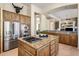 Kitchen island with gas cooktop, granite countertop, and stainless steel refrigerator at 34463 N 99Th Way, Scottsdale, AZ 85262