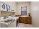 Well-lit laundry room with modern washer and dryer, cabinetry, and tiled floor at 34463 N 99Th Way, Scottsdale, AZ 85262