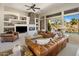 Bright living room featuring leather furniture, a stone fireplace, and backyard views at 34463 N 99Th Way, Scottsdale, AZ 85262